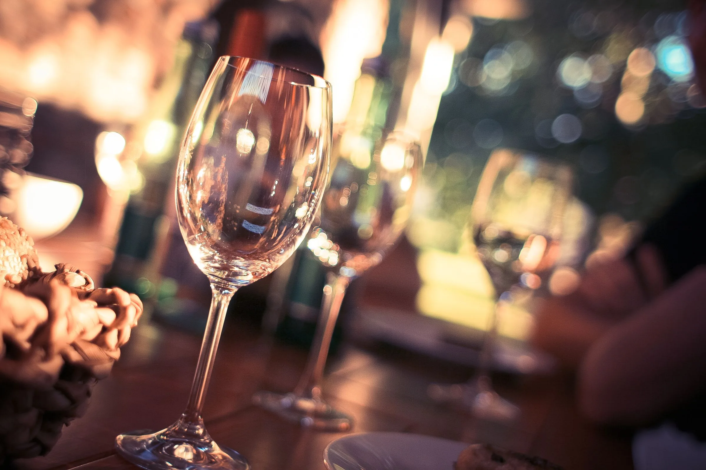 Warm, wazig kaarslicht bij een glas wijn