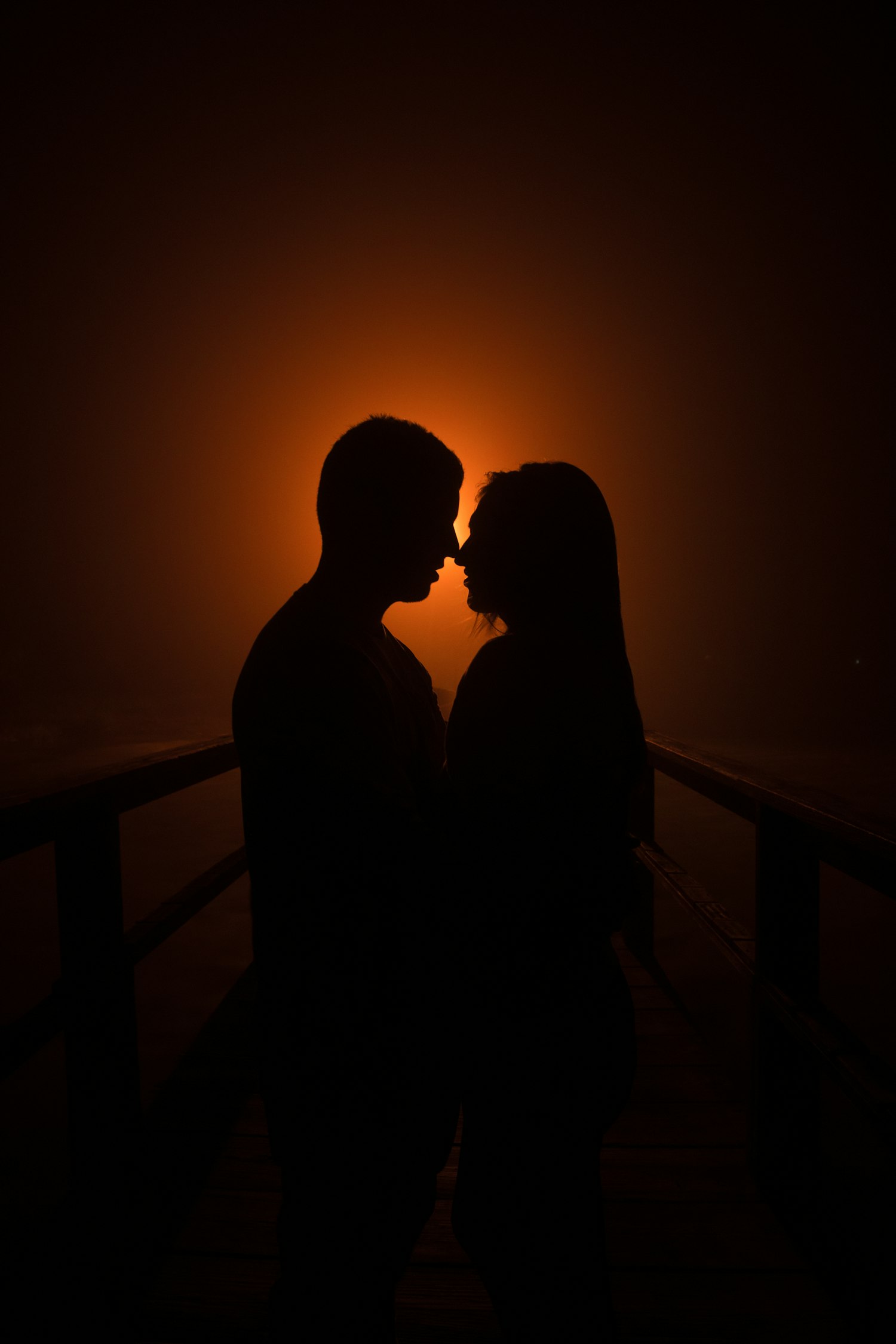 Het silhouet van een paar, dicht bij elkaar in warm gedempt licht